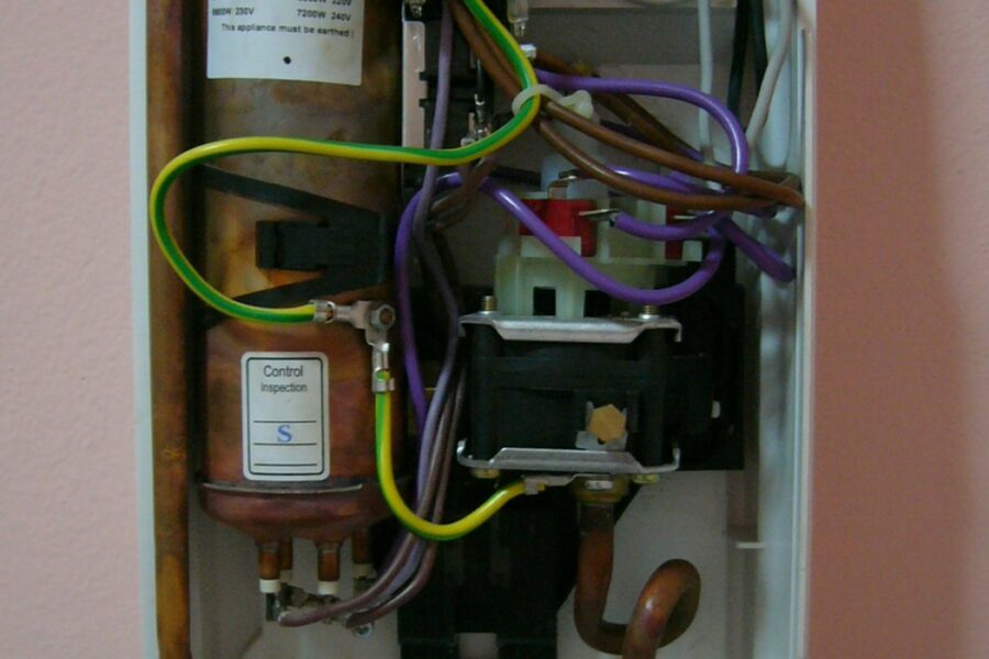 Elektrische doorstroomboiler aan de wand in een badkamer