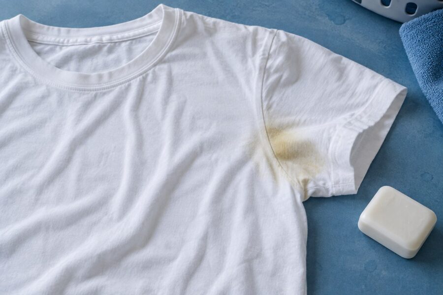Wit katoenen T-shirt met een gele okselvlek op een blauwe ondergrond