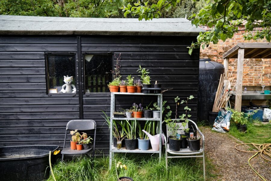Algemeen houten tuinhuis in een ommuurde tuin, geen Keter-model