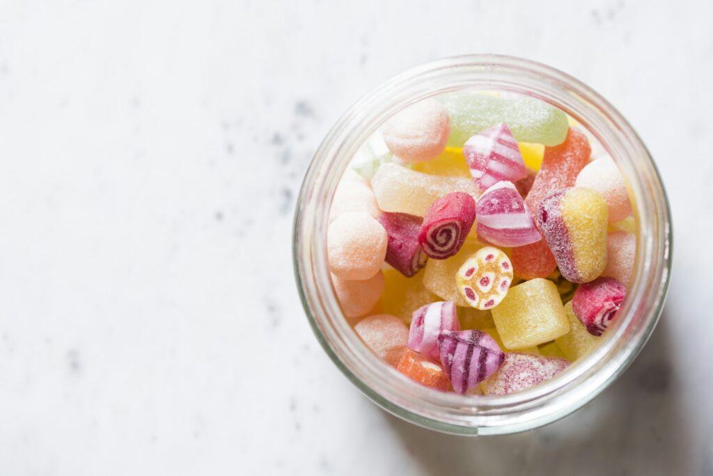 Gekleurde gummies in een glazen snoeppot op een keukenaanrecht