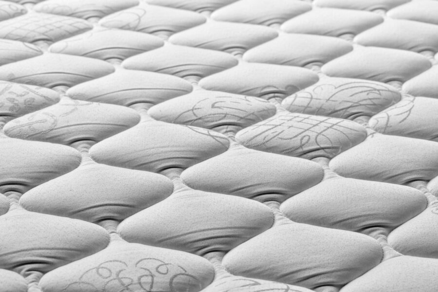 Close-up van een matrasnaad die met een zaklamp wordt gecontroleerd