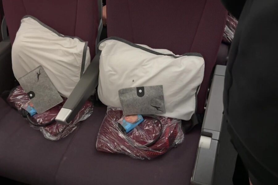Stoelen in de economyclass van een vliegtuig met kussens en dekens