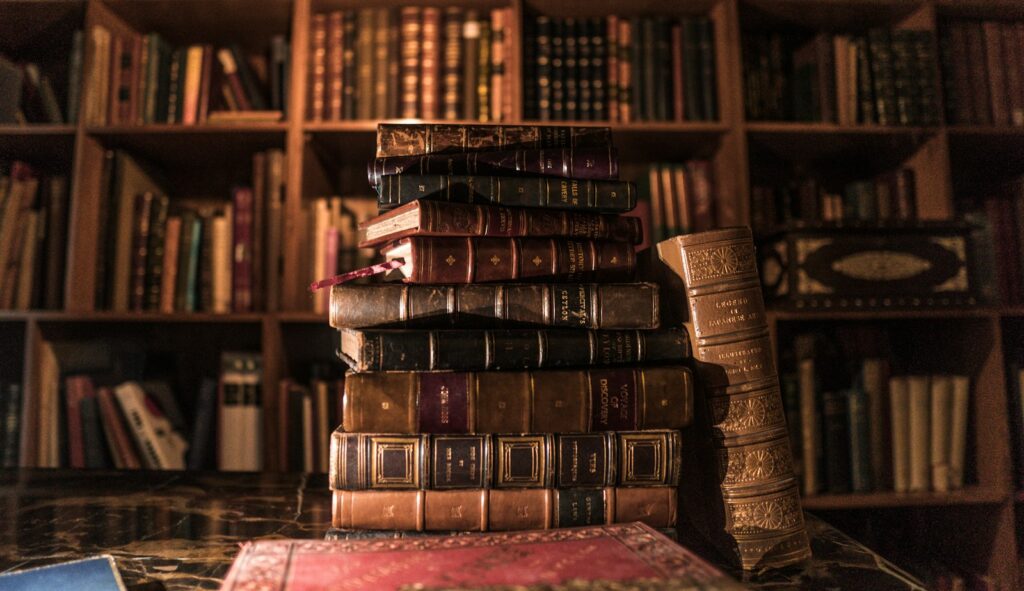 Een stapel oude boeken op een plank, een plek waar boekenluizen zich graag ophouden