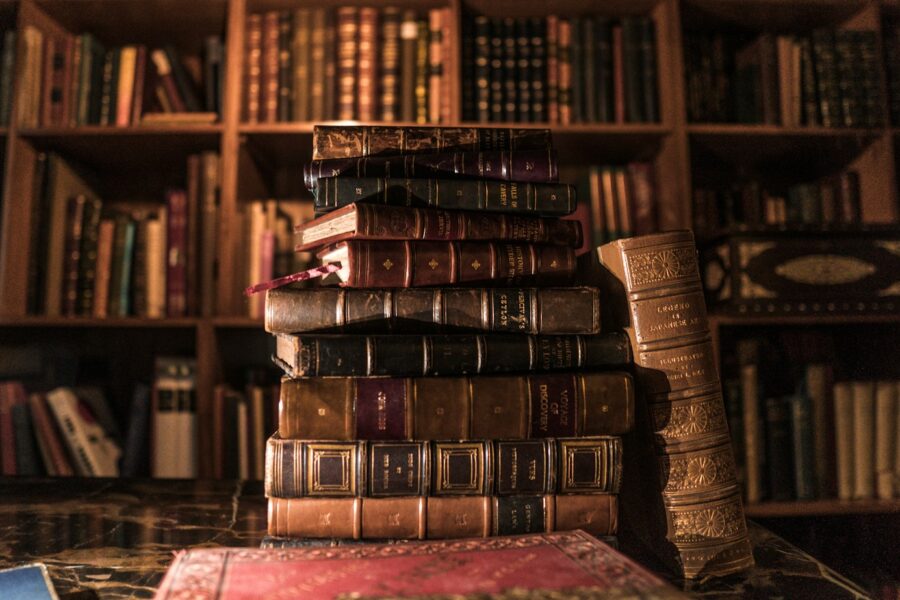 Een stapel oude boeken op een plank, een plek waar boekenluizen zich graag ophouden