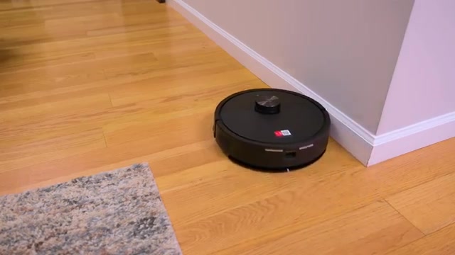 Zwarte robotstofzuiger uit de Q7-serie van Roborock op een houten vloer